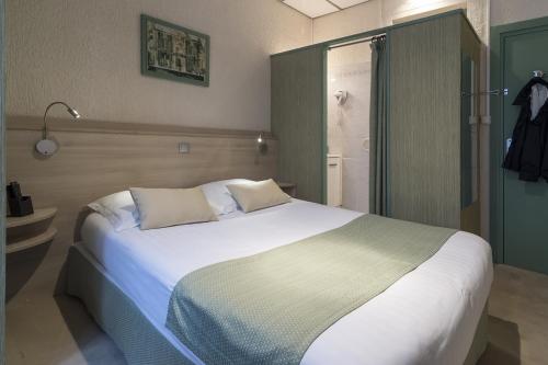 a bedroom with a large white bed and a shower at Hotel Du Moulin d'Or in Lille