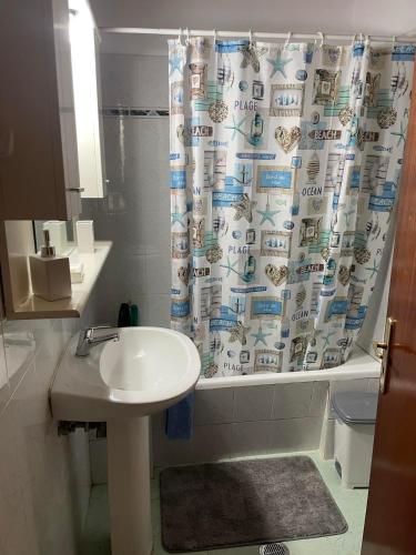a bathroom with a sink and a shower curtain at HeleNik Holiday House in Halikounas