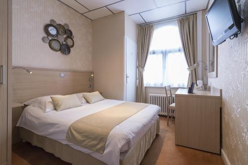 a hotel room with a bed and a television at Hotel Du Moulin d'Or in Lille