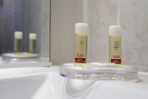 a bathroom with two bottles of moisturizers on a sink at Hotel Du Moulin d'Or in Lille