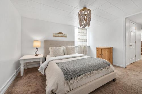 a white bedroom with a bed and a chandelier at Stylish & Bright 4BR - Close To Whitworth in Nine Mile Falls