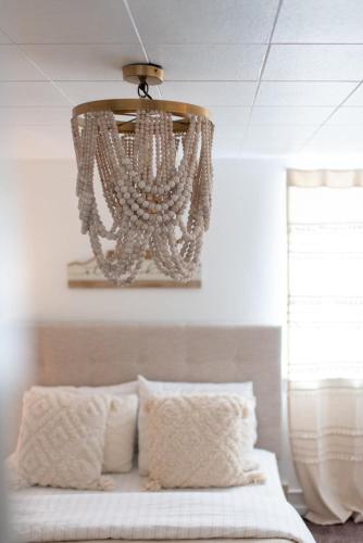 a chandelier hanging over a bed in a bedroom at Stylish & Bright 4BR - Close To Whitworth in Nine Mile Falls
