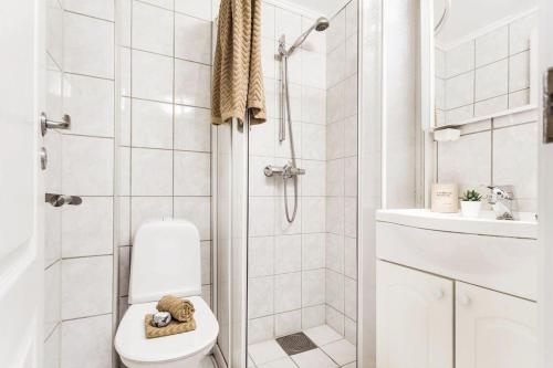 a white bathroom with a toilet and a shower at Charming studio apartment in Bergen
