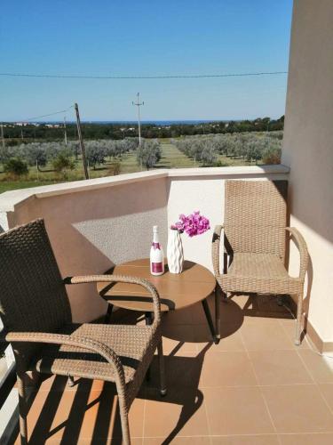 patio con mesa y sillas en el balcón en SMOKVICA en Savudrija