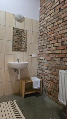 Un baño con lavabo y pared de ladrillo. en Poganty - Obora, en Giżycko