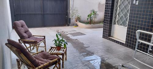 a patio with two chairs and a potted plant at Aloha Hostel&CoWorking - Prox Aeroporto e Consulado in Porto Alegre