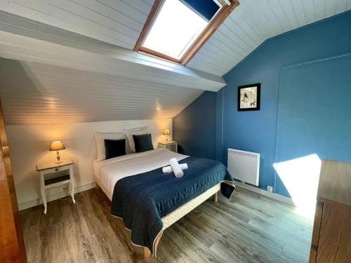 um quarto com uma cama com paredes azuis e uma clarabóia em Gite du Meunier, au bord du Cosson, 4 étoiles em Vineuil