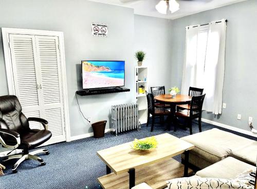 een woonkamer met een bank en een tafel bij 3 bedrooms 1 bath APT, 10 min to Manhattan! in Long Island City