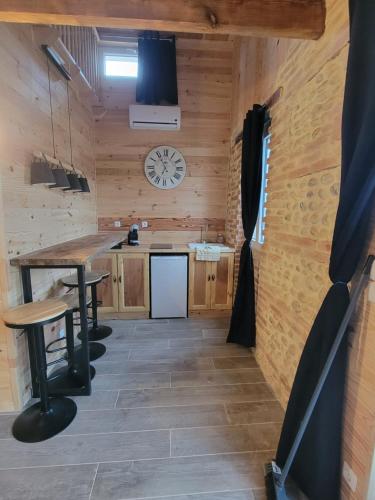 a kitchen with a table and a clock on the wall at Domaine de buffevent in Cintegabelle