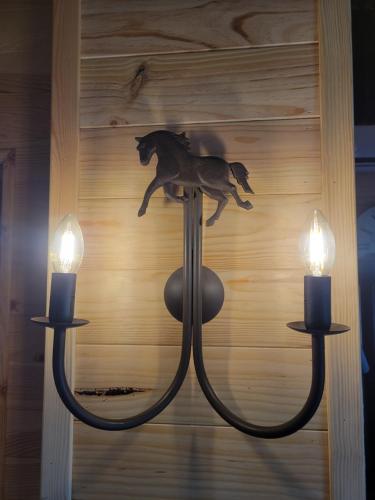 a chandelier with a horse on it with two candles at Domaine de buffevent in Cintegabelle