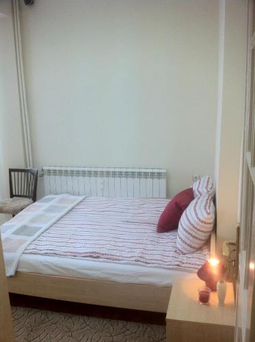 a bedroom with a white bed with red pillows at Gogol 2BR Apartment in Sofia