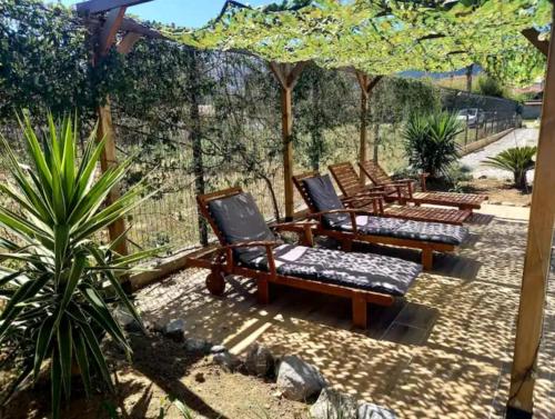 3 chaises assises sur une terrasse sous un parasol dans l'établissement Studio 37 m2, à Saint-Génis