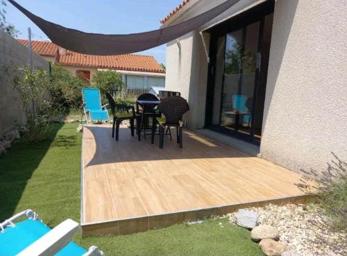 un patio avec une table et des chaises sur une terrasse dans l'établissement Studio 37 m2, à Saint-Génis