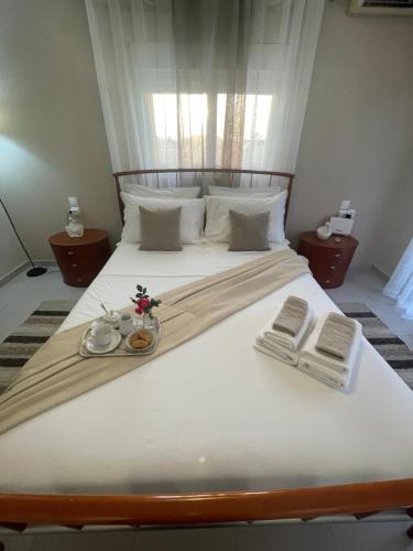 a large white bed with two towels and books on it at Summer Diamond in Kremasti