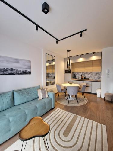 a living room with a blue couch and a table at Julis Apartment in Zlatibor