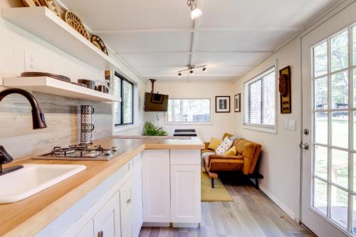 una cocina con armarios blancos y fregadero en Georgia Tiny Home on Farm Retreat Hike On-Site! en Lithonia