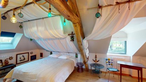 a bedroom with a canopy bed with white curtains at Château de Saint-Clair in Bordeaux-Saint-Clair