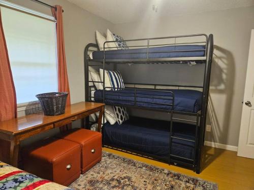 a room with two bunk beds with a desk and a window at Chic Rancher 7BR Compound Near Graceland & Airport in Memphis