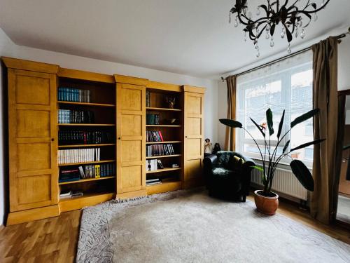 ein Wohnzimmer mit Bücherregalen und einer Topfpflanze in der Unterkunft Exklusives Haus mit Garten in Hannover