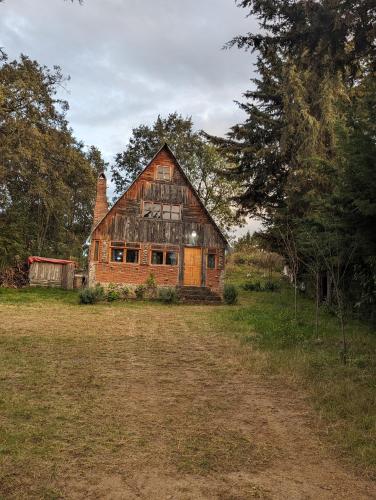 an old wooden barn in a field with trees at RedStone Cabin in El Oro de Hidalgo