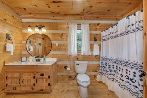 a bathroom with a toilet and a sink and a mirror at Autumns Peak in Sevierville
