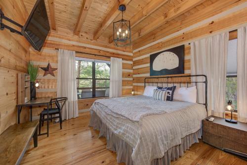 a bedroom in a log cabin with a bed and a desk at Autumns Peak in Sevierville