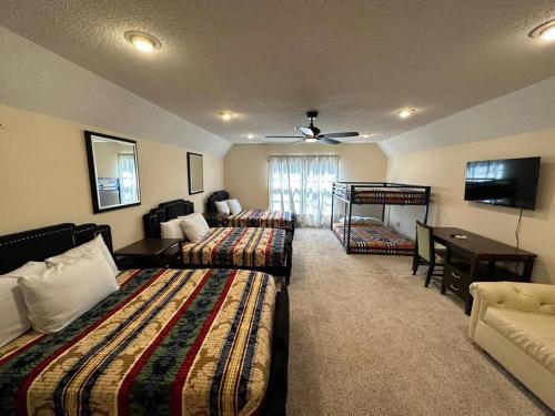 Habitación con 2 camas, sofá y TV. en Peaceful & Elegant Sleeps 16 with Pool Near Mall en Memphis