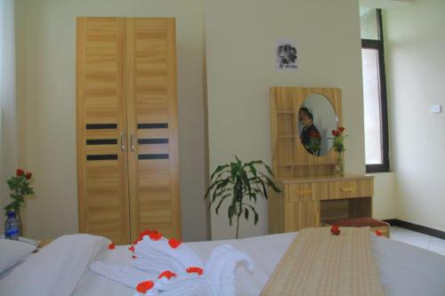 a bedroom with a bed and a mirror and a girl at Ekshesh Hotel Bishoftu in Debre Zeyit