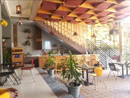 a restaurant with tables and chairs and a staircase at Ekshesh Hotel Bishoftu in Debre Zeyit