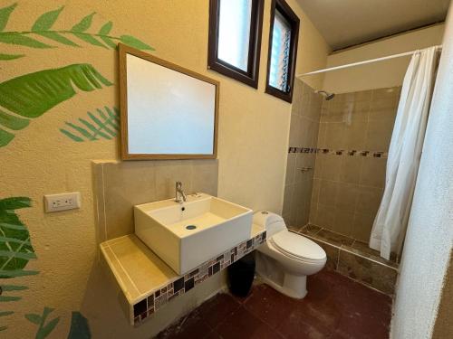 a bathroom with a sink and a toilet at Hotel Panajachel Oasis in Panajachel