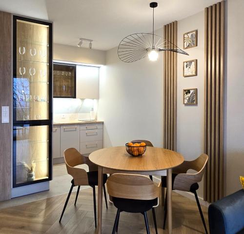 a kitchen and dining room with a table and chairs at Apartament Cudny Widok z Sauną - KRAS RESORT in Szklarska Poręba
