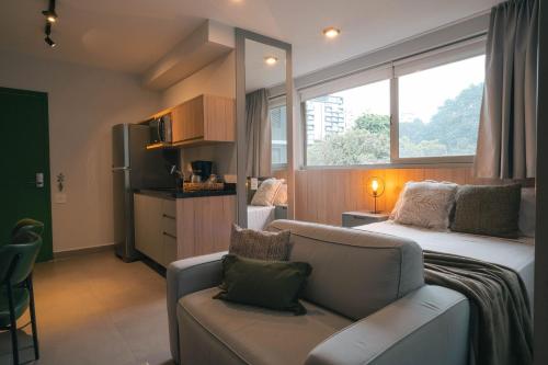 a room with a couch and a bed and a window at VN Melo Alves in Sao Paulo