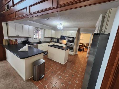uma cozinha com armários brancos e um balcão preto em Southern Large Lake Front Custom Estate, Sleeps 16 em Olive Branch