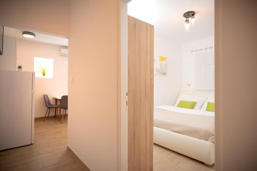 a small bedroom with a bed and a table at Villa Rajski Dvor in Bol
