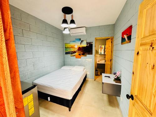 a small bedroom with a bed in a room at Hostal Camila’s in Tamanique