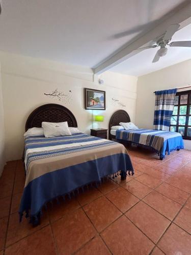 - une chambre avec 2 lits avec des draps bleus et blancs dans l'établissement HOTEL VILLAS MARIAS, à Puerto Arista