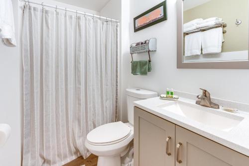 a white bathroom with a toilet and a sink at Charming Updated Retreat Walk to Lake Stevens! in Lake Stevens