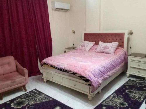 a bedroom with a bed and a chair at غرفه فندقيه للإيجار ( فيلا الاسعد ) امام مول العرب in 6th Of October