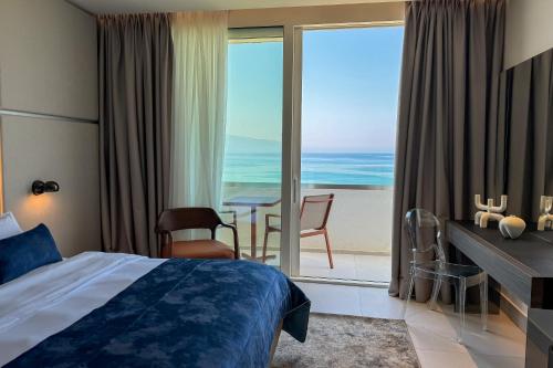 a hotel room with a bed and a view of the ocean at Abi's Hotel & SPA Vlore in Vlorë
