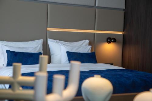 a bedroom with a bed with blue sheets and pillows at Abi's Hotel & SPA Vlore in Vlorë