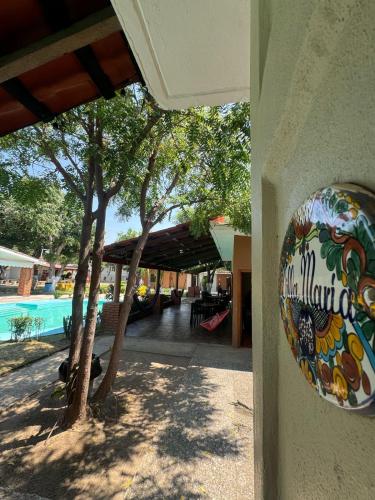 un panneau sur le côté d'un bâtiment à côté d'une piscine dans l'établissement HOTEL VILLAS MARIAS, à Puerto Arista