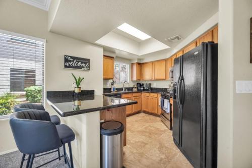 a kitchen with a black refrigerator and a counter at Comfy Condo with Heated Pool and Gym in Phoenix
