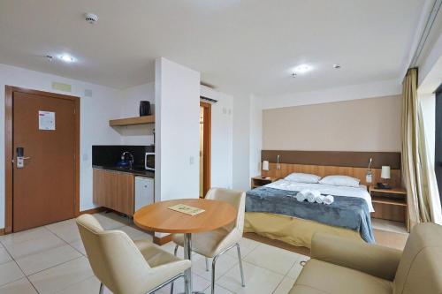 Una habitación de hotel con una cama, una mesa y sillas. en Alugueasy - Hotel Athos Bulcão, en Brasilia