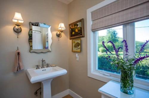 a bathroom with a sink and a vase of flowers at Exclusive Wine Country Estate - The Haven in Healdsburg
