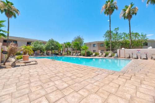 a swimming pool with palm trees in a resort at Comfy Condo with Heated Pool and Gym in Phoenix