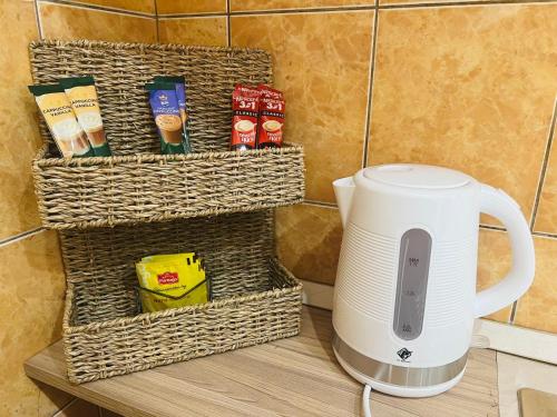 a white coffee maker sitting on a counter with baskets at Aurum29 in Doboj