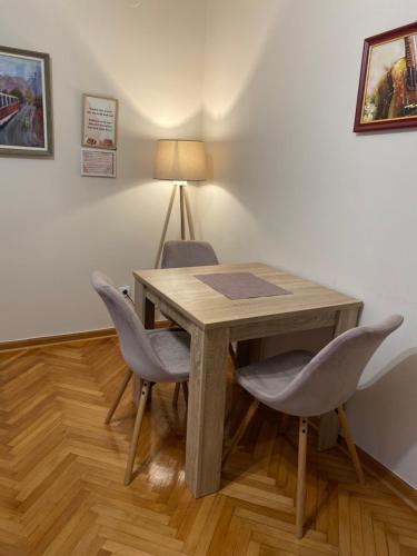 a wooden table with two chairs and a lamp at Cozy Trg in Lazarevac