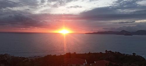 a sunset over the ocean with the sun setting at Vila Natalia in Petrovac na Moru
