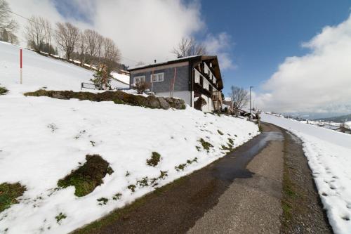 a house on the side of a snow covered road at Nuessli in Wildhaus