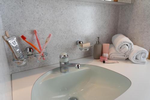 a bathroom counter with a sink and towels at Nuessli in Wildhaus